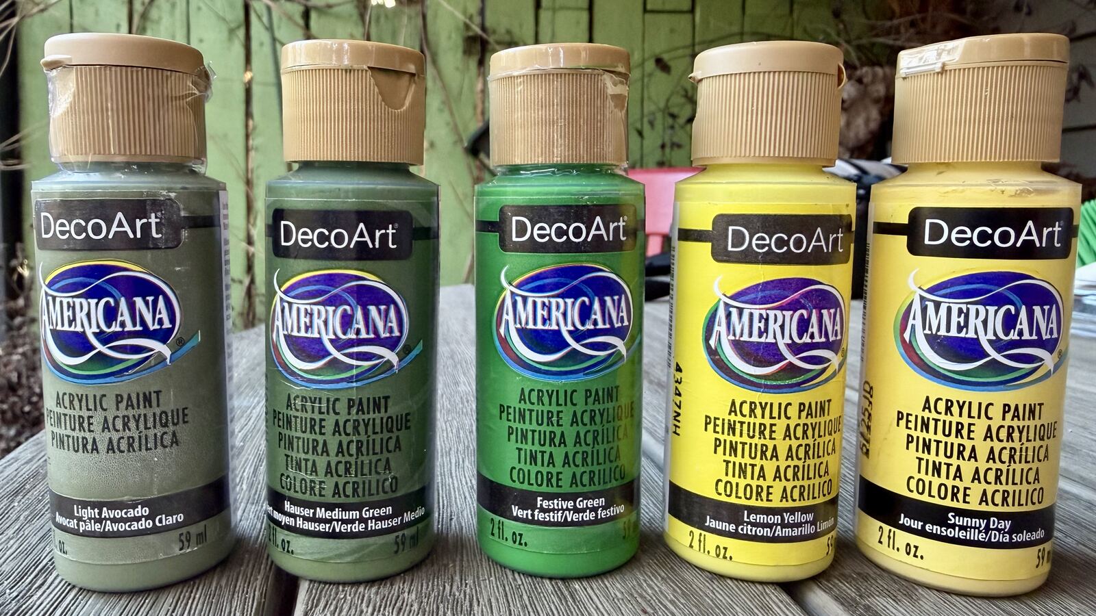 Bottles of DecoArt Americana acrylic paint in greens and yellows